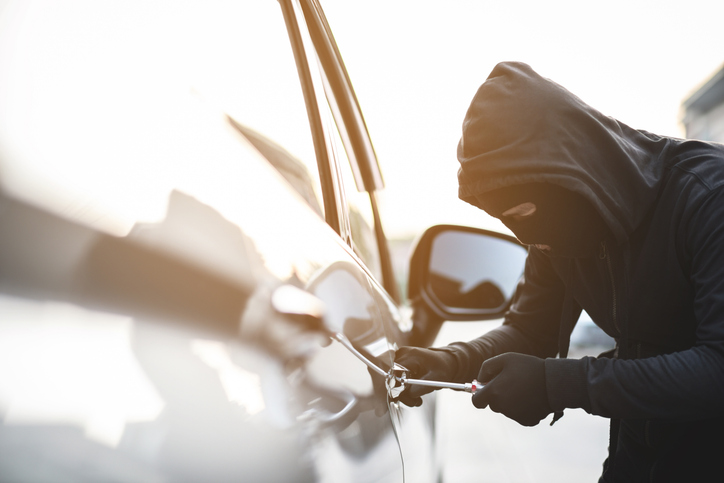 Close up of a car thief holding a screwdriver