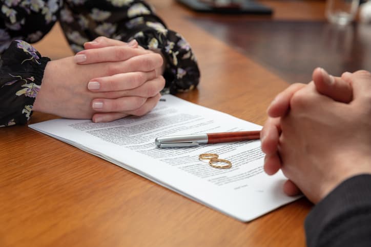 A couple signing divorce papers over a table