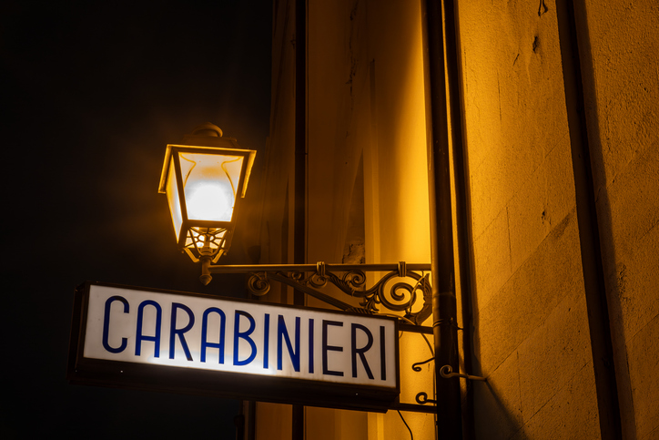  A sign and street lamp at night says Carabinieri, or Military Police, in Italian