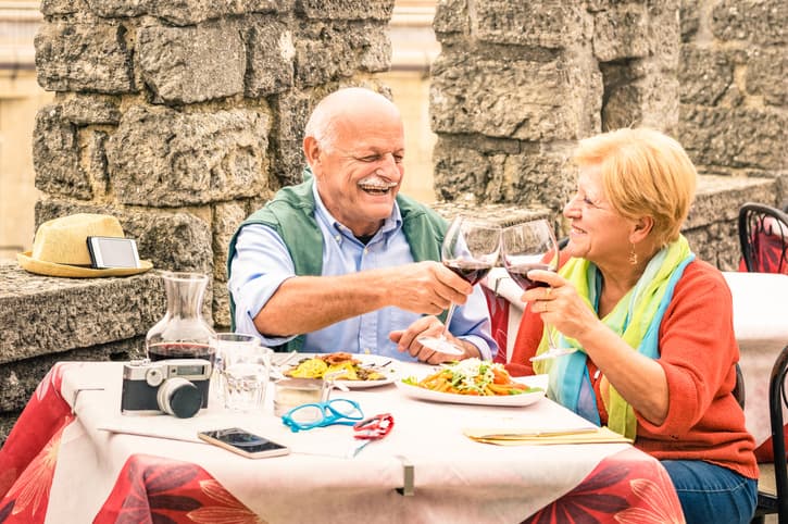 Senior couple having fun and eating at restaurant during travel